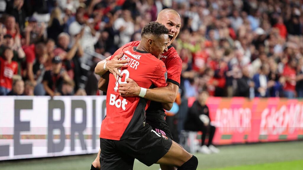 Photo montrant la joie de 2 joueurs du Stade Rennais se tenant entre leurs bras après un but