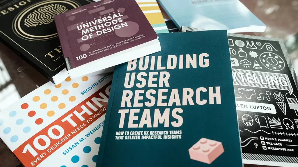 pile de livres posés sur une table, couverture principale "Building User Research Teams"